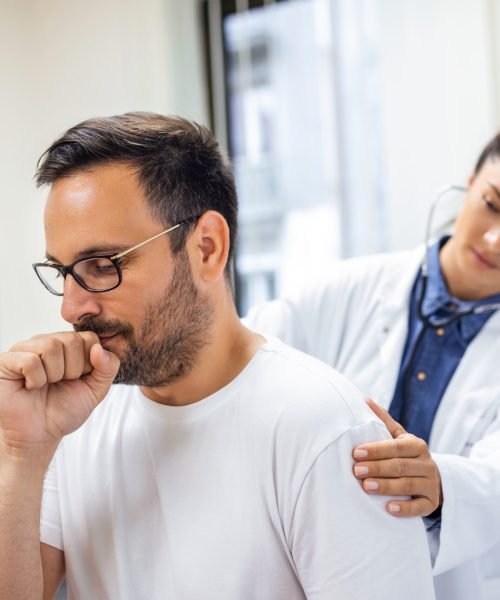 A female doctor at the clinic performs auscultation of the lungs of a patient with symptoms of coronavirus or pneumonia.